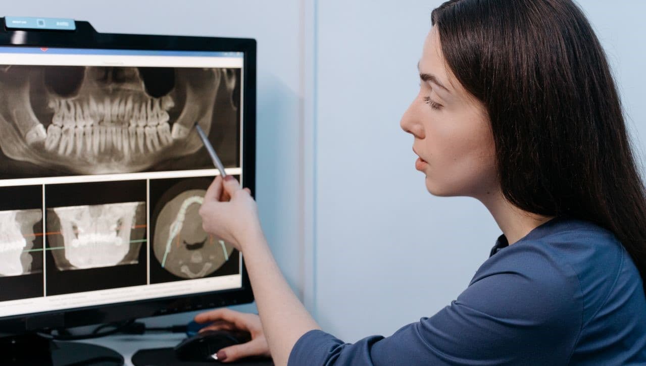 Clinician reviewing dental X-ray imaging on screen